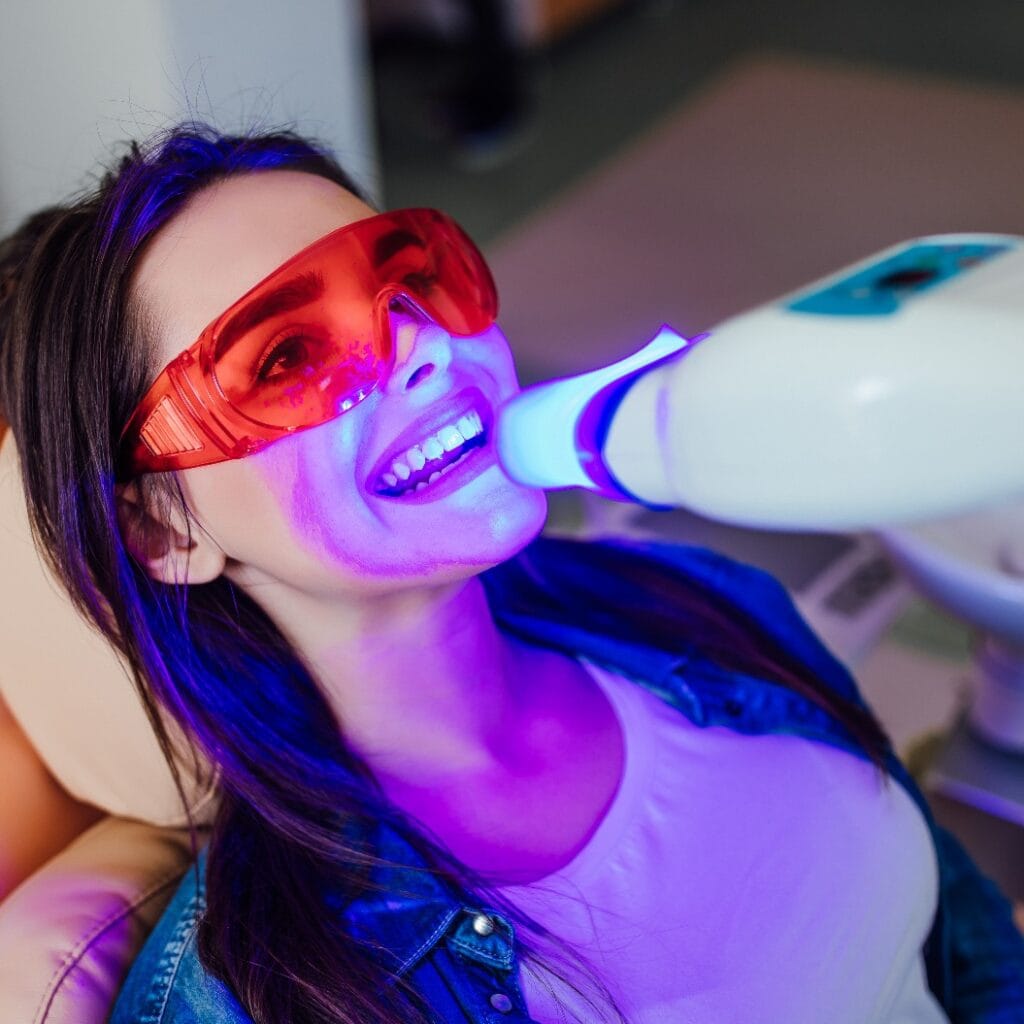 Teeth whitening for woman. Bleaching of the teeth at modern dentist clinic.